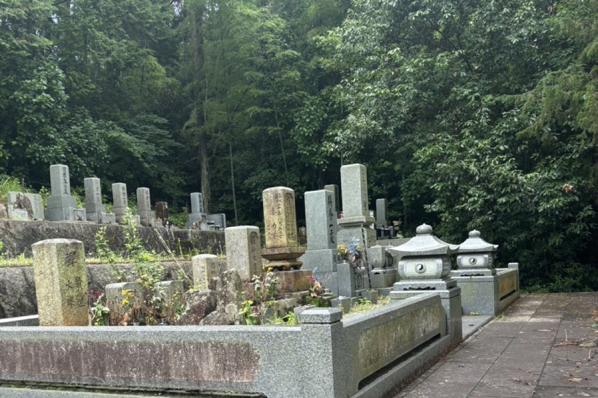 森に囲まれた山の墓地、古い墓石が並ぶ段々の区画