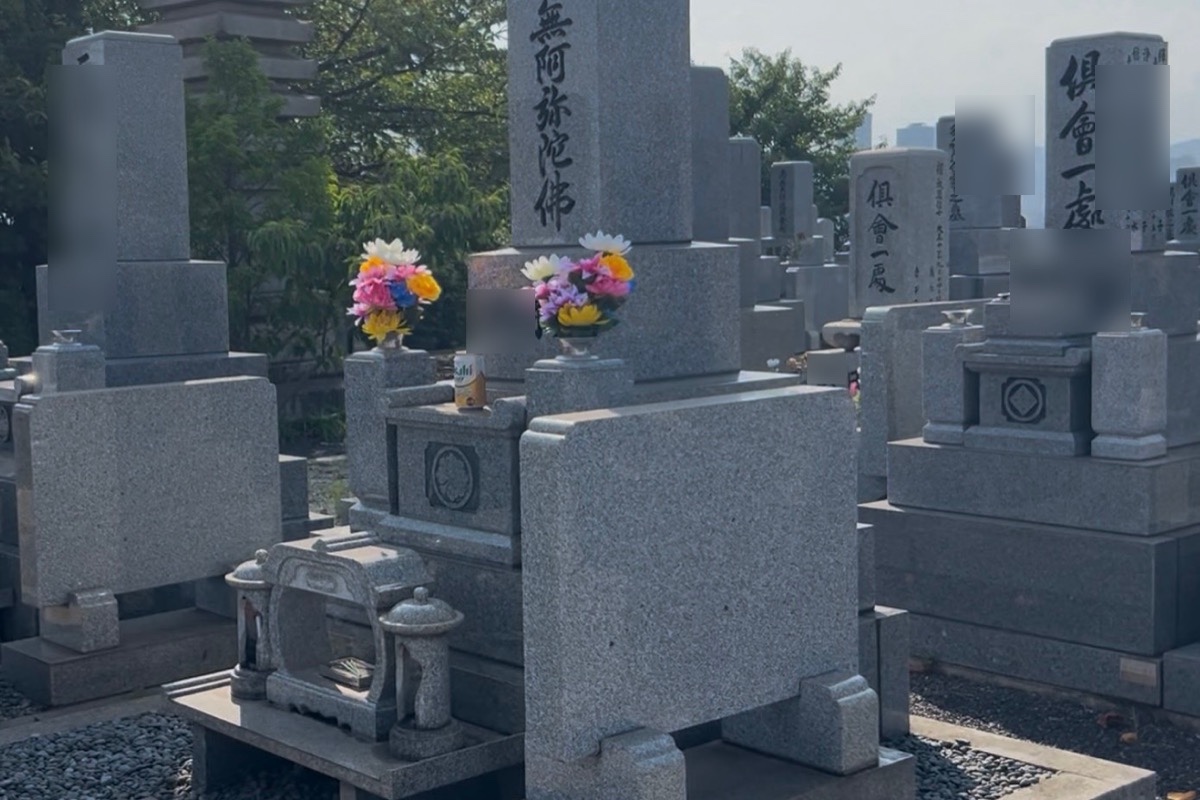 花立てに色とりどりの造花が供えられた墓前