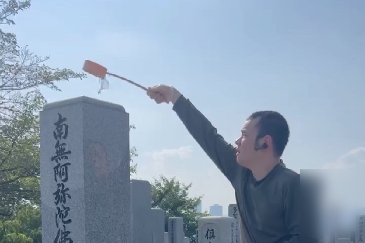 墓石の上からひしゃくで水をかける代表