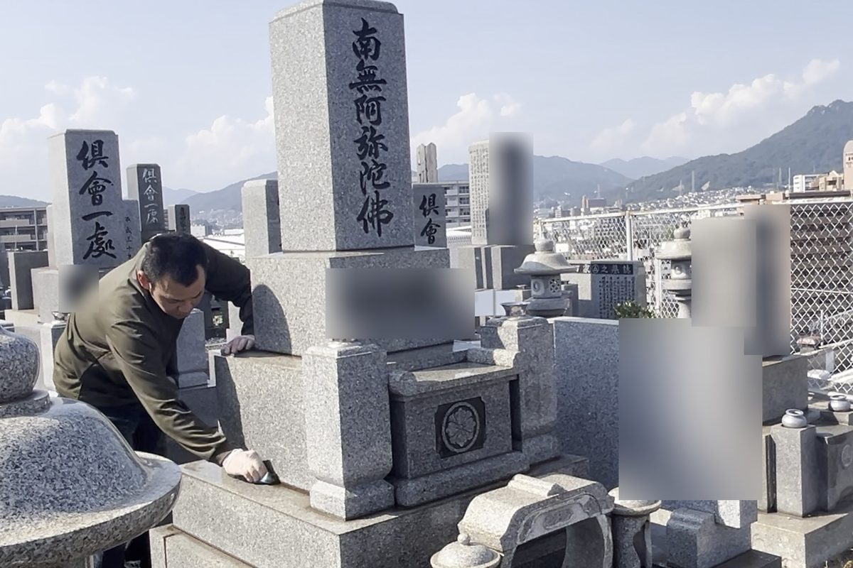 墓石をスポンジで丁寧に拭き上げる手元