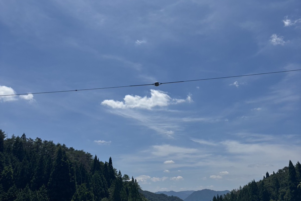 山あいの墓地から見上げた青空