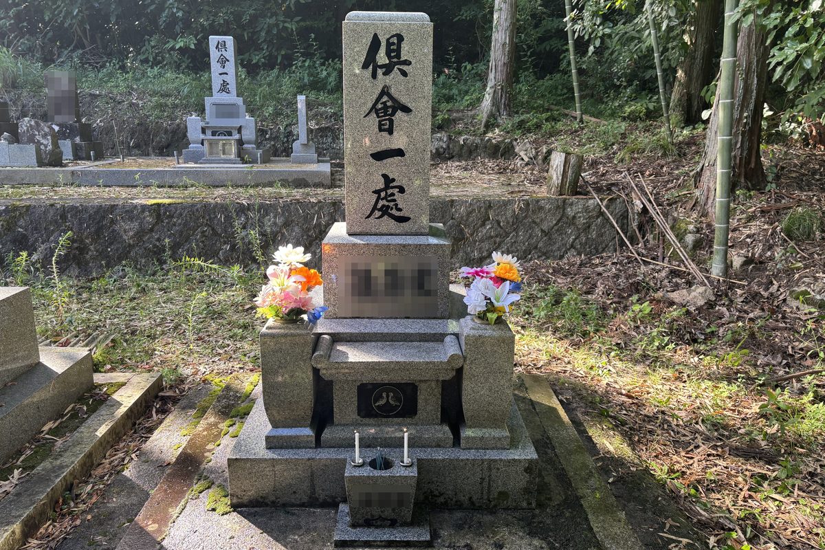 花立てに色とりどりの造花を供えた、清掃後のお墓