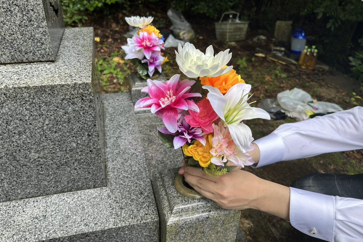 花立てに色とりどりのお花を供える手元